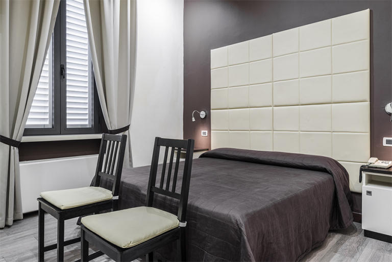 Foto camera hotel con letto con testata in pelle